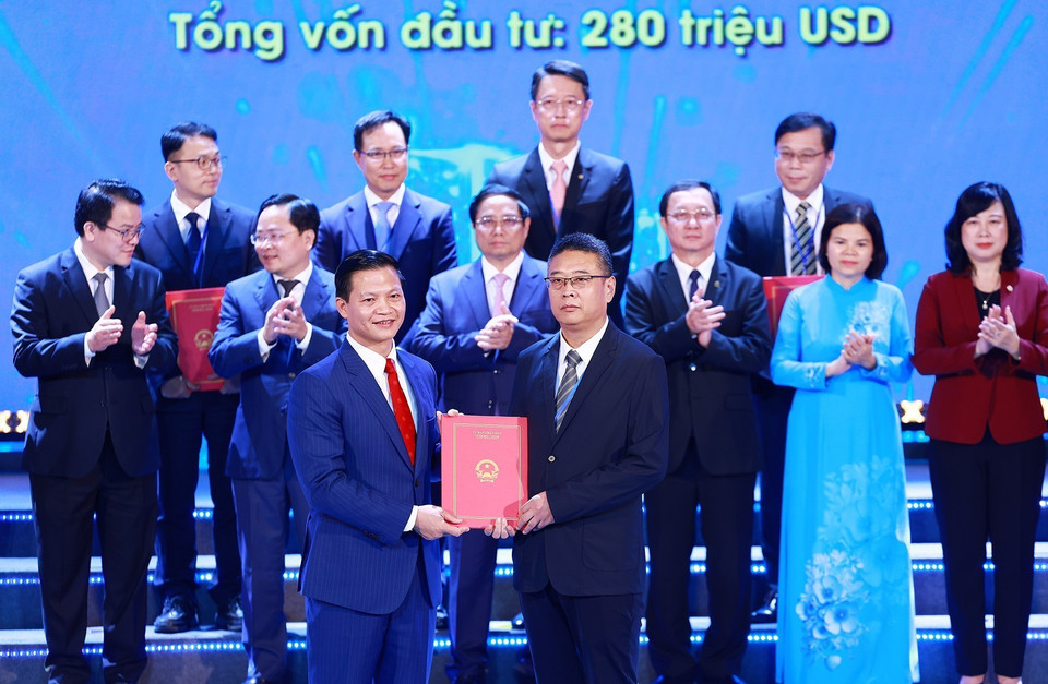 Chủ tịch UBND tỉnh Bắc Ninh Vương Quốc Tuấn trao Quyết định chủ trương đầu tư, giấy chứng nhận đăng ký đầu tư, biên bản ghi nhớ cho các nhà đầu tư. (Ảnh: Dương Giang/TTXVN)