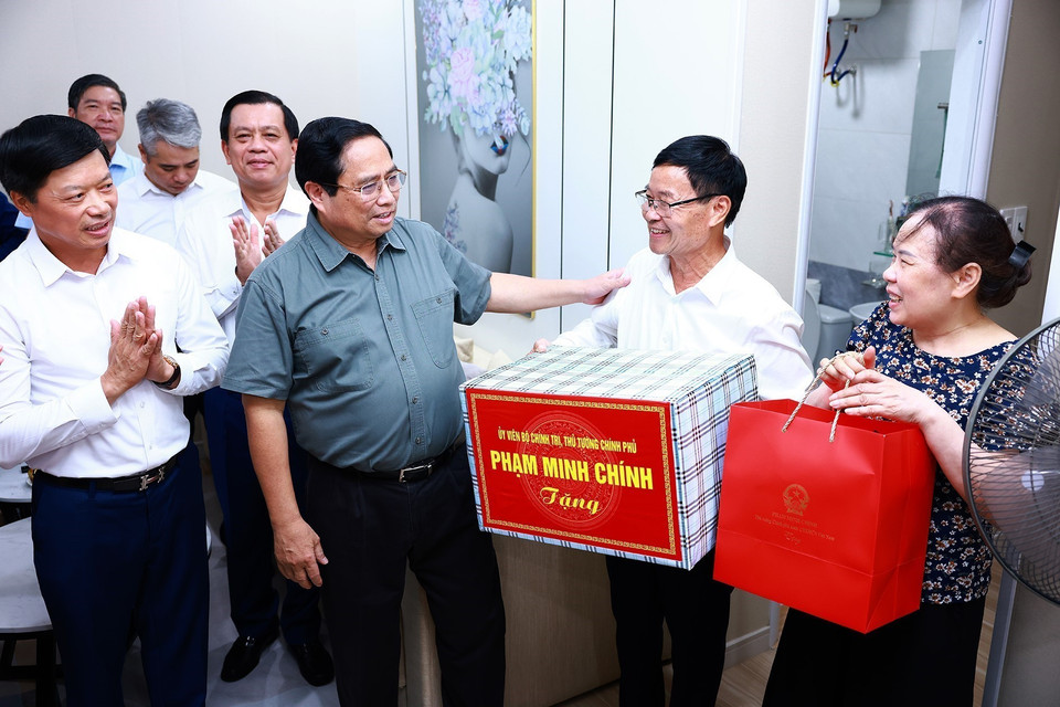 Thủ tướng Phạm Minh Chính tặng quà cho hộ dân khu nhà ở xã hội tại thành phố Bắc Ninh. (Ảnh: Dương Giang/TTXVN)