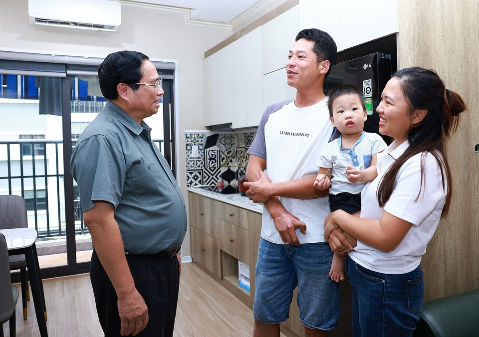 Thủ tướng Phạm Minh Chính thăm một hộ gia đình trẻ tại khu nhà ở xã hội của thành phố Bắc Ninh. (Ảnh: Dương Giang/TTXVN)