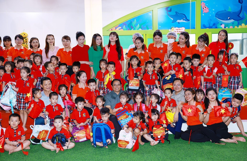Thủ tướng Phạm Minh Chính với giáo viên và học sinh trường mầm non Cát Tường trong khu nhà ở xã hội tại thành phố Bắc Ninh. (Ảnh: Dương Giang/TTXVN)