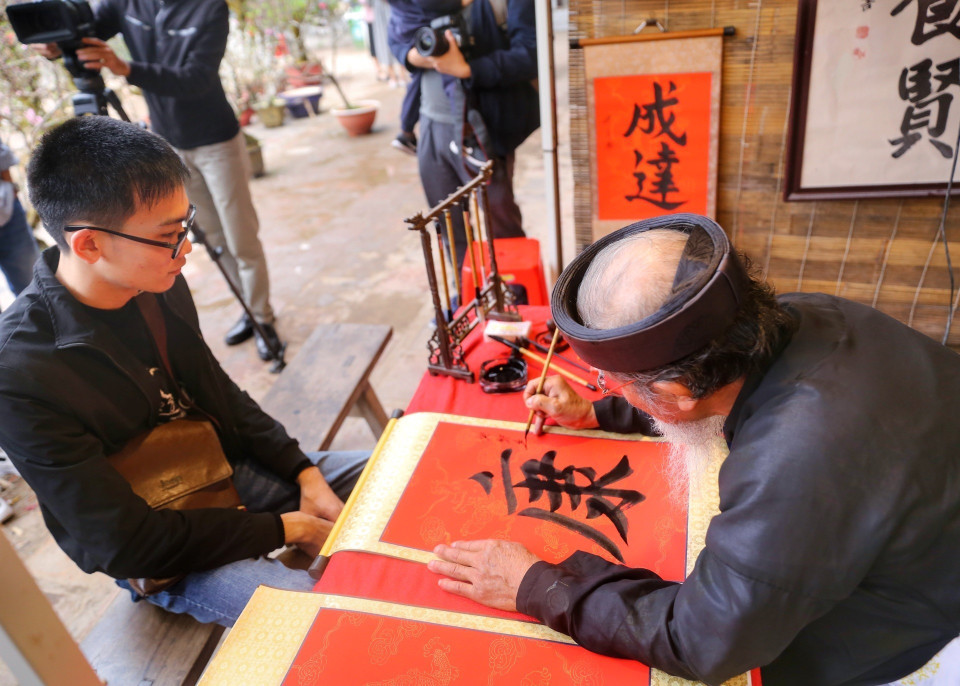 Các nghệ nhân viết thư pháp tại Hội chữ Xuân. (Ảnh: Tuấn Đức/TTXVN)