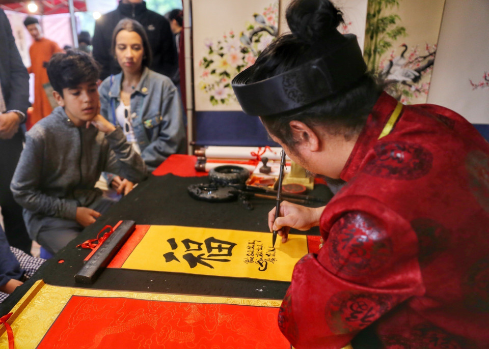 Các nghệ nhân viết thư pháp tại Hội chữ Xuân. (Ảnh: Tuấn Đức/TTXVN)