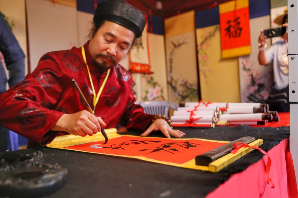 Các nghệ nhân viết thư pháp tại Hội chữ Xuân. (Ảnh: Tuấn Đức/TTXVN)