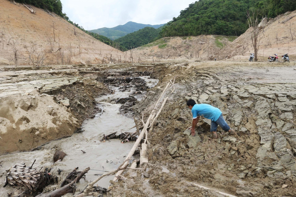 Lớp bùn sâu hiện ra khi lòng hồ cạn nước. (Ảnh: Nguyễn Oanh/TTXVN)
