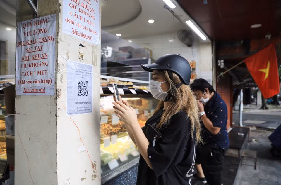 Các cửa hàng kinh doanh ăn uống phải in mã QR-code được cung cấp, dán ở lối ra vào để khách sử dụng điện thoại thông minh quét mã khi đến mua hàng. (Ảnh: Thành Đạt/TTXVN)