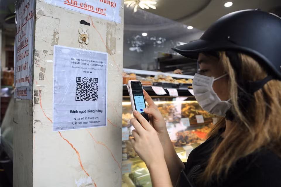 Khách sẽ được các chủ cửa hàng yêu cầu quét mã QR trước khi mua hàng. (Ảnh: Thành Đạt/TTXVN)
