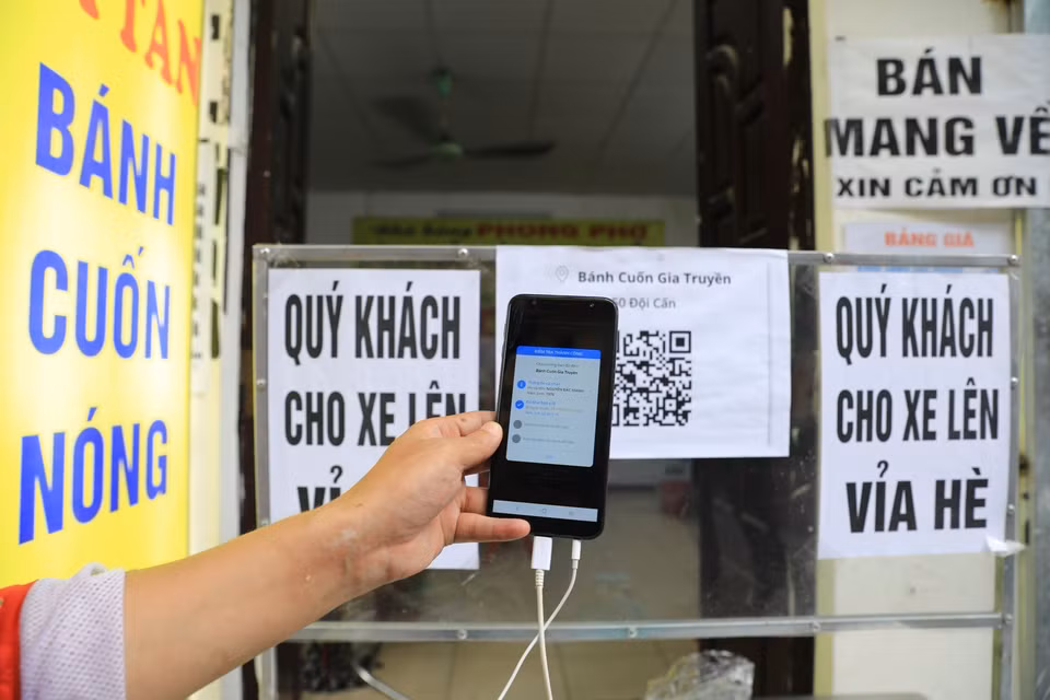 Sau khi quét thành công, màn hình điện thoại sẽ hiện thông tin của người đến mua hàng và tình trạng khai báo y tế. (Ảnh: Thành Đạt/TTXVN)