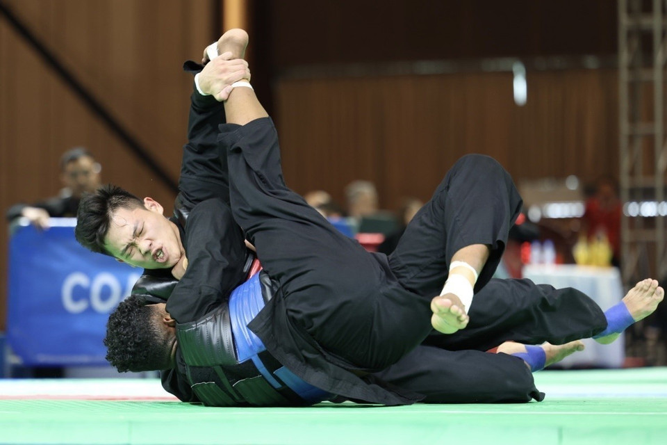 Vận động viên Nguyễn Tấn Sang (đai đỏ, trên) thắng đối thủ Bin Sheik Alau'ddin (đai xanh, Singapore), giành huy chương Vàng ở hạng cân 75-80kg nam. (Ảnh: Minh Quyết/TTXVN)