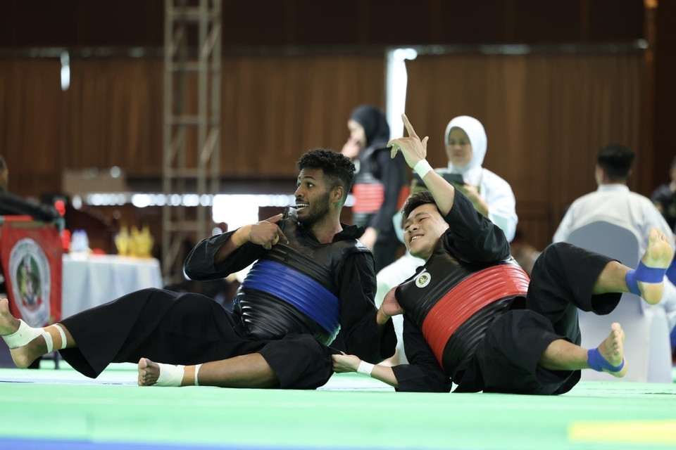 Vận động viên Nguyễn Tấn Sang (đai đỏ, phải) thắng đối thủ Bin Sheik Alau'ddin (đai xanh, Singapore), giành huy chương Vàng ở hạng cân 75-80kg nam. (Ảnh: Minh Quyết/TTXVN)