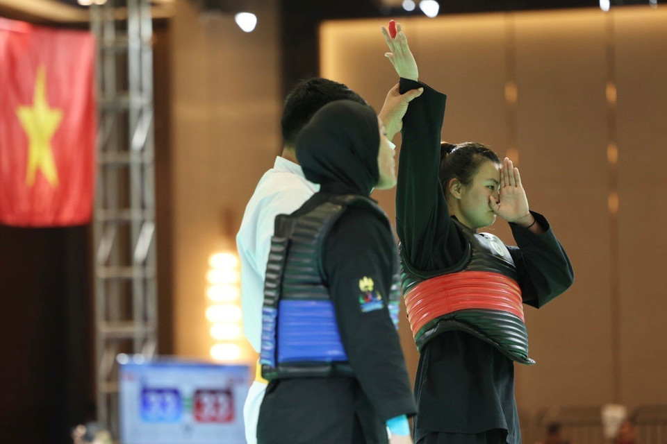 Vận động viên Quàng Thị Thu Nghĩa (đai đỏ, phải) đánh bại đối thủ người Indonesia (đai xanh) trong trận chung kết đối kháng hạng cân 65-70kg để mang về tấm huy chương Vàng thứ 3 cho đội tuyển Pencak Silat Việt Nam. (Ảnh: Minh Quyết/TTXVN)