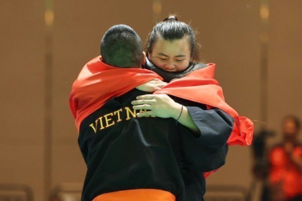 Vận động viên Quàng Thị Thu Nghĩa vui mừng ôm chầm lấy Huấn luyện viên Nguyễn Văn Hùng khi xuất sắc đánh bại Vận động viên người Indonesia trong trận chung kết đối kháng hạng cân 65-70kg để mang về tấm huy chương Vàng thứ 3 cho đội tuyển Pencak Silat Việt Nam. (Ảnh: Minh Quyết/TTXVN)