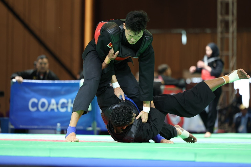 Vận động viên Nguyễn Tấn Sang (đai đỏ, trên) thắng Bin Sheik Alau'ddin (đai xanh, Singapore), giành huy chương Vàng ở hạng cân 75-80kg nam. (Ảnh: Minh Quyết/TTXVN)