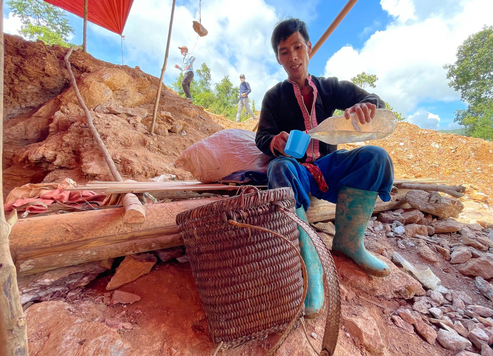 Một phu vàng tạm nghỉ uống nước vào buổi trưa ở điểm khai thác vàng Nậm Khá, xã Mù Cả, huyện Mường Tè, tỉnh Lai Châu. (Ảnh: Nhóm PV TTXVN tại Lai Châu)