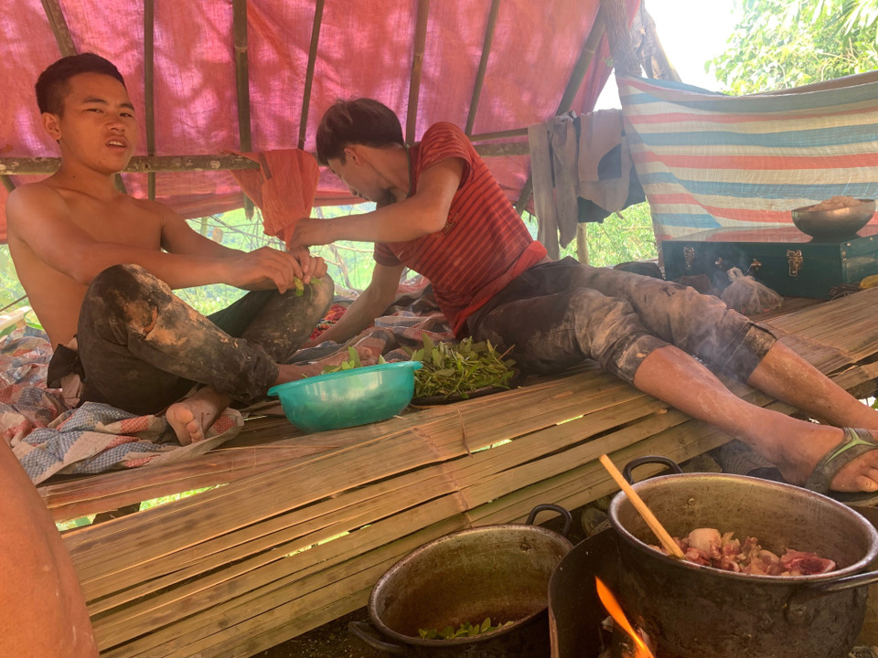 Hai thanh niên nấu cơm trưa trong điểm khai thác vàng Nậm Khá, xã Mù Cả, huyện Mường Tè, tỉnh Lai Châu. (Ảnh: Nhóm PV TTXVN tại Lai Châu)