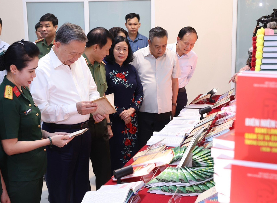 Chủ tịch nước Tô Lâm xem các ấn phẩm, tài liệu tuyên truyền bảo vệ an ninh Tổ quốc tại phường Cửa Đông. (Ảnh: Lâm Khánh/TTXVN)