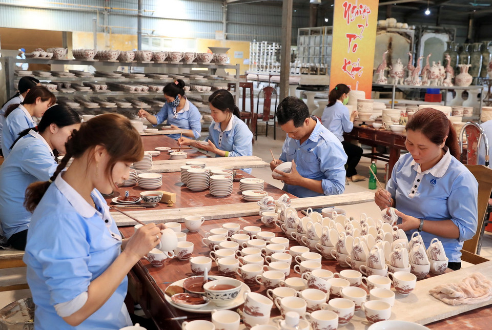 Những bàn tay tinh hoa tạo nên sản phẩm truyền thống của gốm Chu Đậu. (Ảnh: Thống Nhất/TTXVN)