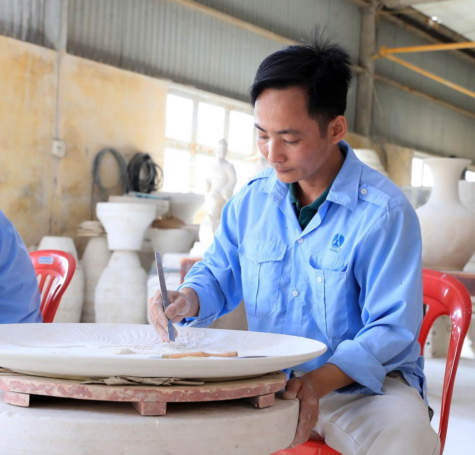 Những bàn tay tinh hoa tạo nên sản phẩm truyền thống của gốm Chu Đậu. (Ảnh: Thống Nhất/TTXVN)