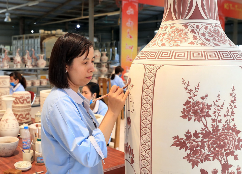 Những bàn tay tinh hoa tạo nên sản phẩm truyền thống của gốm Chu Đậu. (Ảnh: Thống Nhất/TTXVN)
