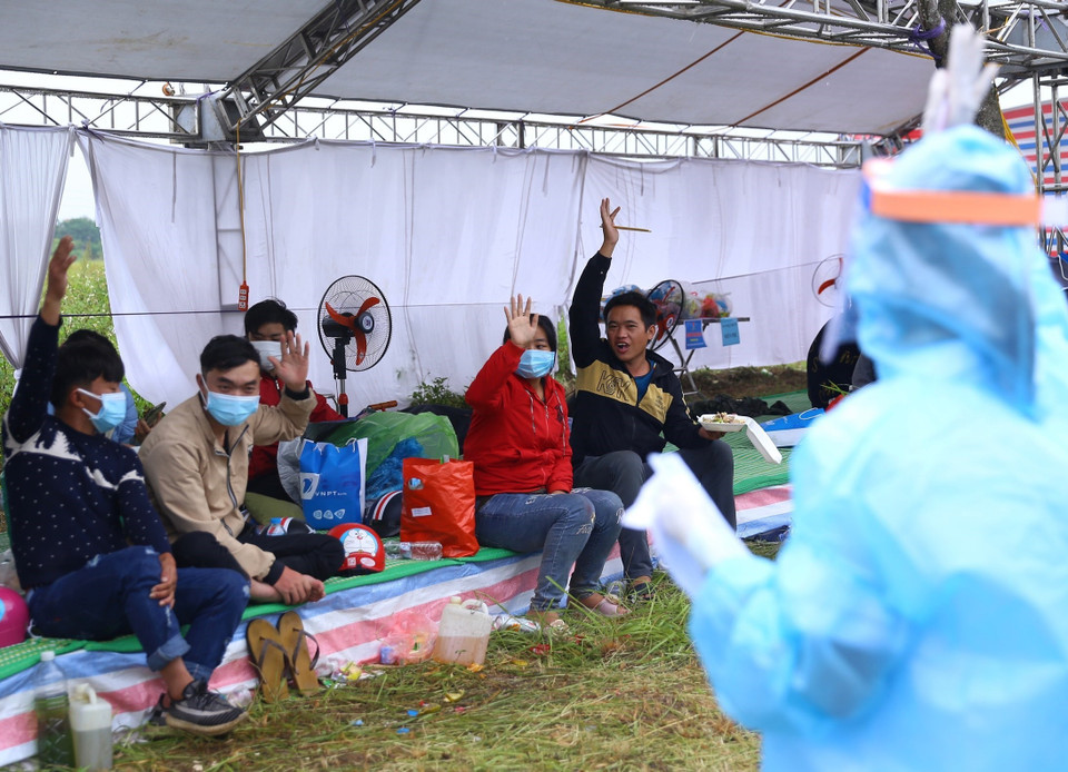 Nhân viên y tế tại khu vực trung chuyển trong Khu công nghiệp hỗ trợ Nam Hà Nội lấy thông tin nơi đến của người dân. (Ảnh: Hoàng Hiếu/TTXVN)