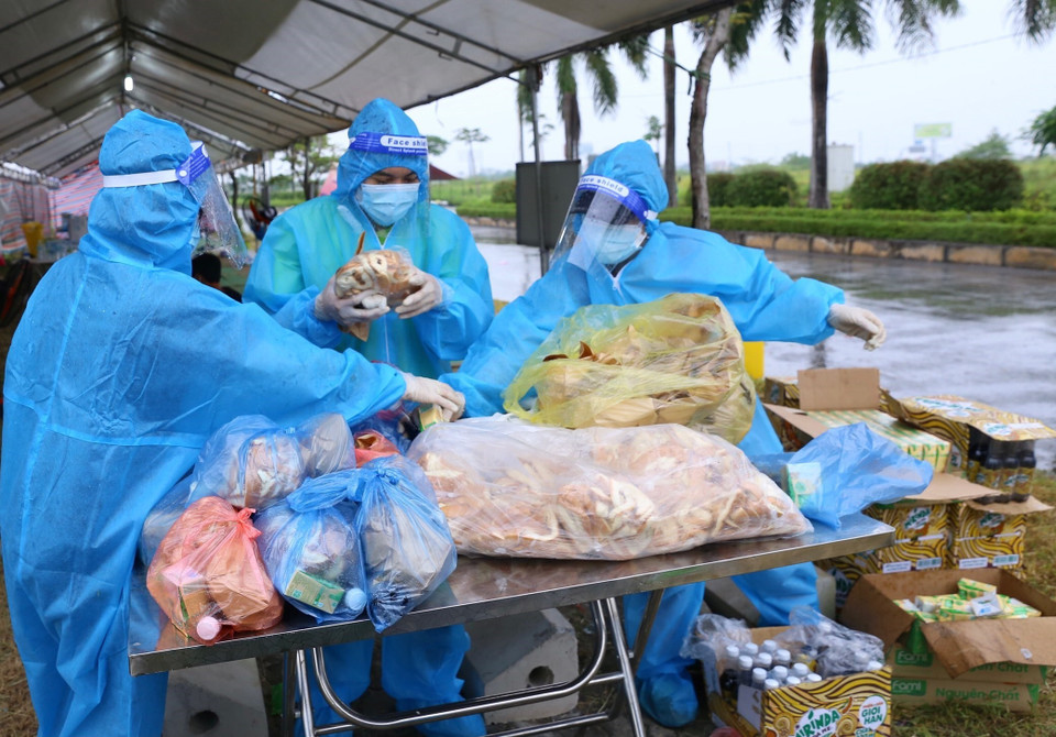 Các nhà hảo tâm chuẩn bị đồ ăn, thức uống hỗ trợ người dân tại điểm trung chuyển Khu công nghiệp hỗ trợ Nam Hà Nội, chiều 9/10. (Ảnh: Hoàng Hiếu/TTXVN)