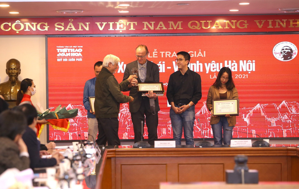 Tiến sỹ Sử học Dương Trung Quốc trao giải “Tác phẩm - Vì tình yêu Hà Nội” cho nhiếp ảnh gia Thomas Billhardt (tác giả Cuốn sách và triển lãm ảnh Hà Nội 1967-1975). (Ảnh: Hoàng Hiếu/TTXVN)
