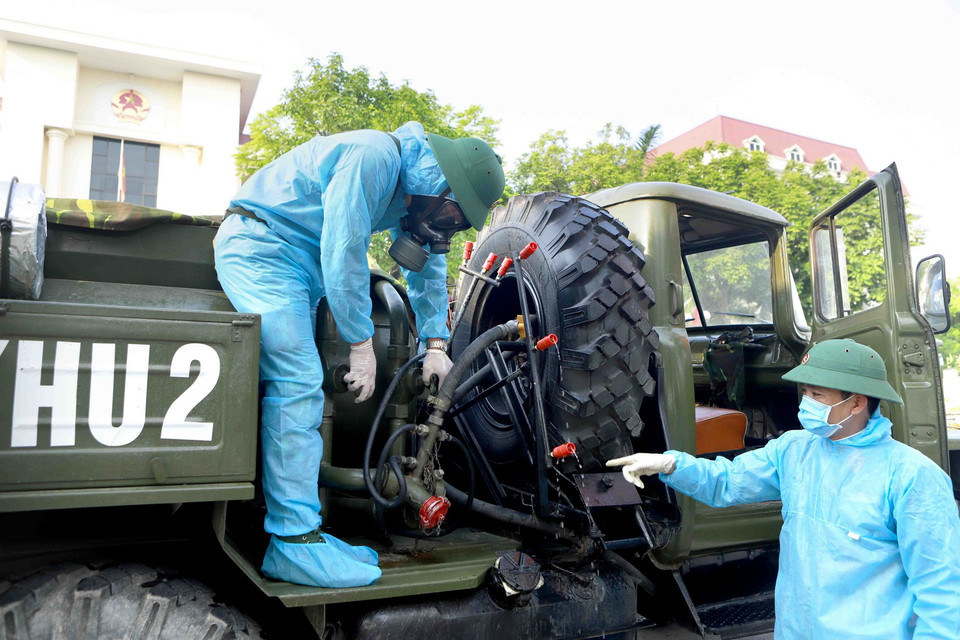 Các chiến sỹ Quân khu 2 vận hành hệ thống phun khử khuẩn chuẩn bị phun tiêu độc khử trùng các địa điểm của thành phố Vĩnh Yên. (Ảnh: Hoàng Hùng/TTXVN)