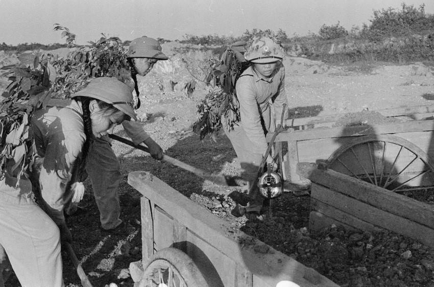 Trong thanh niên, ngày 9/8/1964, Trường Đại học sư phạm Hà Nội phát động phong trào 'Ba sẵn sàng' với khẩu hiệu: Sẵn sàng chiến đấu và gia nhập lực lượng vũ trang; Sẵn sàng học tập và lao động xây dựng cuộc sống mới; Sẵn sàng đi tới nơi nào mà Tổ quốc cần đến. Trong ảnh: Nữ thanh niên xung phong Hà Tĩnh dũng cảm vừa chiến đấu, vừa đảm bảo giao thông thông suốt trên tuyến đường trọng điểm Ngã ba Đồng Lộc trong kháng chiến chống Mỹ, cứu nước. (Ảnh: Văn Sắc/TTXVN)