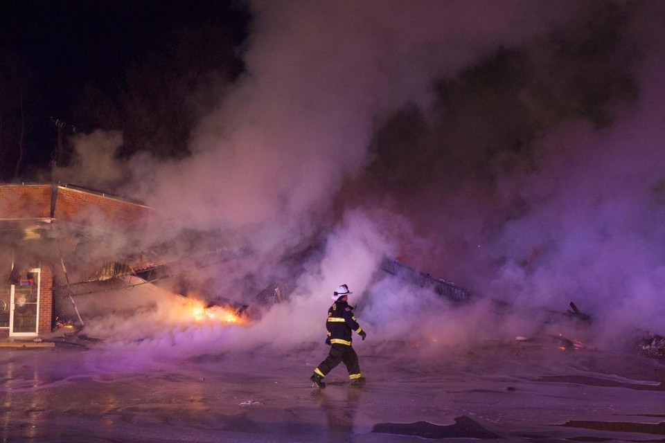 Lính cứu hỏa dập tắt một đám cháy sau cuộc biểu tình này 25/11 ở Dellwood, Missouri.