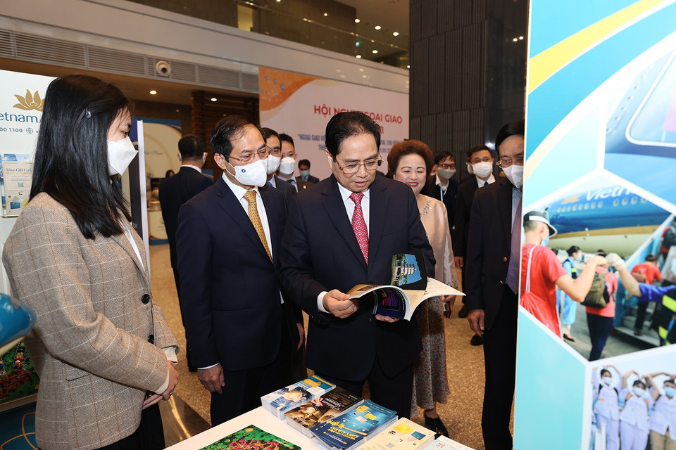 Thủ tướng Phạm Minh Chính và các đại biểu tham quan trưng bày sách, báo, tạp chí về các hoạt động ngoại giao của Việt Nam. (Ảnh: Dương Giang/TTXVN)