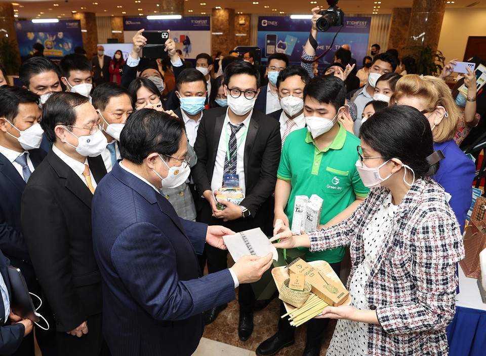 Thủ tướng Phạm Minh Chính và các đại biểu tham quan trưng bày các sản phẩm ứng dụng công nghệ sáng tạo. (Ảnh: Dương Giang/TTXVN)