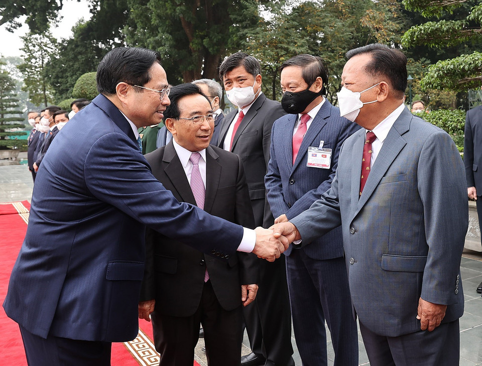 Thủ tướng Lào Phankham Viphavanh giới thiệu với Thủ tướng Phạm Minh Chính thành viên đoàn đại biểu cấp cao Lào. (Ảnh: Dương Giang/TXVN) 