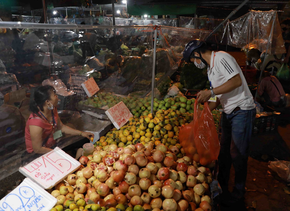 Người dân đến mua sắm tại chợ đầu mối Nam Hà Nội, quận Hoàng Mai luôn giữ khoảng cách an toàn giữa người bán, người mua. (Ảnh: Vũ Sinh/TTXVN)