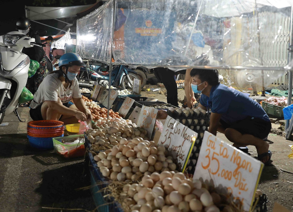 Các hoạt động mua, bán tại chợ đầu mối Nam Hà Nội, quận Hoàng Mai đều phải đảm bảo giữ khoảng cách an toàn và có tấm kính chắn giữa người bán, người mua. (Ảnh: Vũ Sinh/TTXVN)