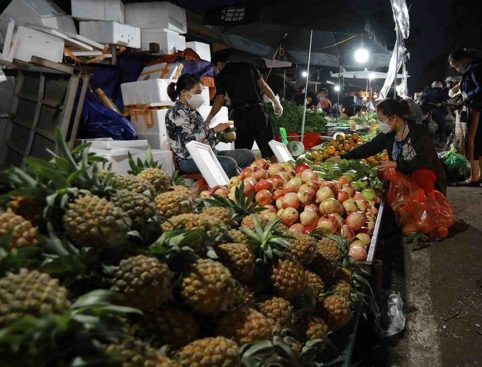 Người dân đến mua sắm tại chợ đầu mối Nam Hà Nội, quận Hoàng Mai luôn giữ khoảng cách an toàn giữa người bán, người mua. (Ảnh: Vũ Sinh/TTXVN)