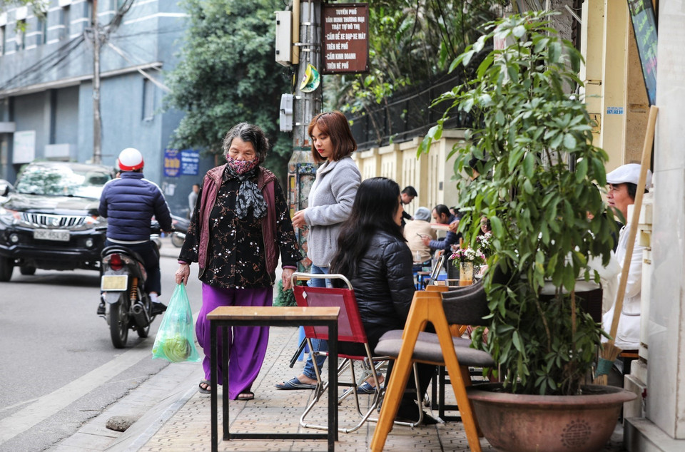 Trên tuyến phố Trúc Bạch (quận Ba Đình), mặc dù đã có biển báo cấm kinh doanh trên hè phố nhưng vẫn diễn ra tình trạng các hàng quán kê bàn ghế tràn ra vỉa hè, không còn đường cho người đi bộ. (Ảnh: Thành Đạt/TTXVN)