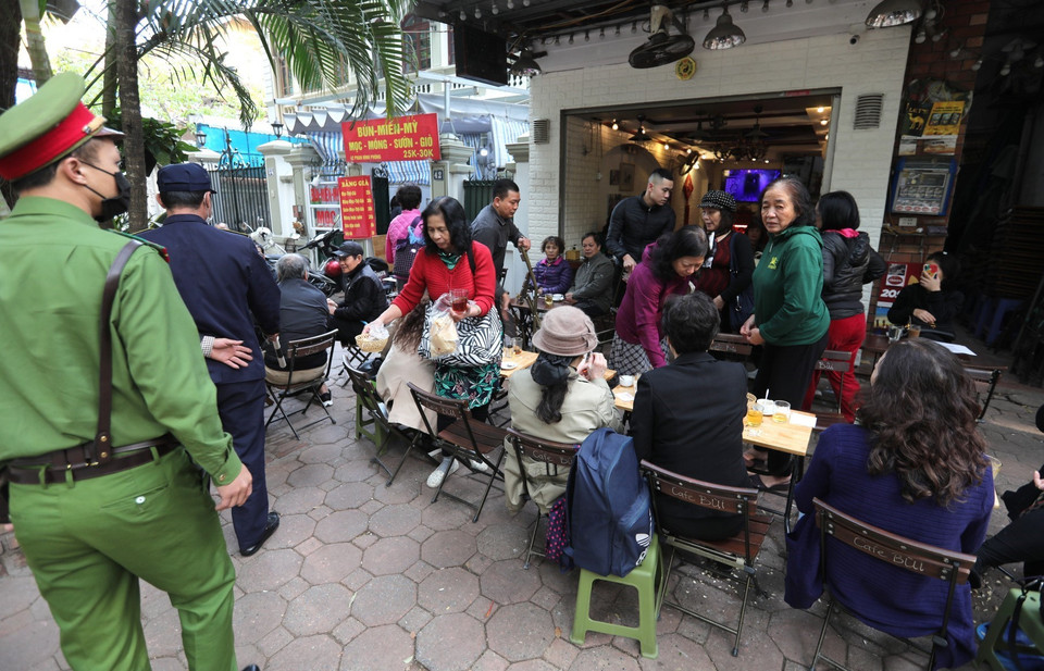 Việc lấn chiếm vỉa hè để kinh doanh như thế này của các cửa hàng ăn uống trên phố Phan Đình Phùng (quận Ba Đình) là vi phạm pháp luật, phải xử phạt chứ không đơn giản chỉ dừng ở chỗ nhắc nhở. (Ảnh: Thành Đạt/TTXVN)