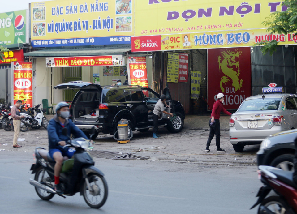  Rửa, đỗ xe ôtô ngay trên vỉa hè phố Võ Thị Sáu, quận Hai Bà Trưng (ảnh chụp chiều 23/3/2021). (Ảnh: Hoàng Hiếu/TTXVN)