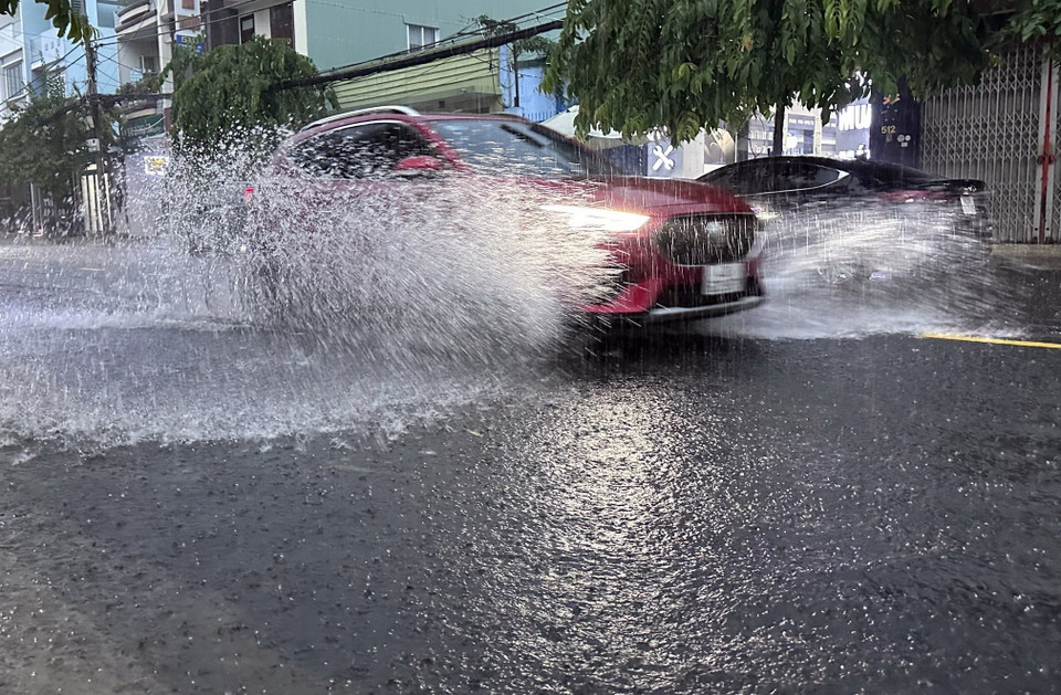 Xe ôtô lao nhanh qua đường bị ngập nước. (Ảnh: Trần Lê Lâm/TTXVN)