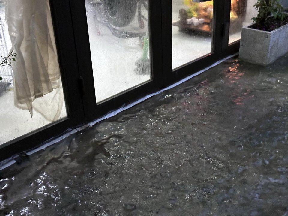 Một nhà dân trên địa bàn quận Thanh Khê phải đóng chặt cửa để hạn chế nước từ ngoài đường tràn vào nhà do mưa lớn liên tục. (Ảnh: Trần Lê Lâm/TTXVN)