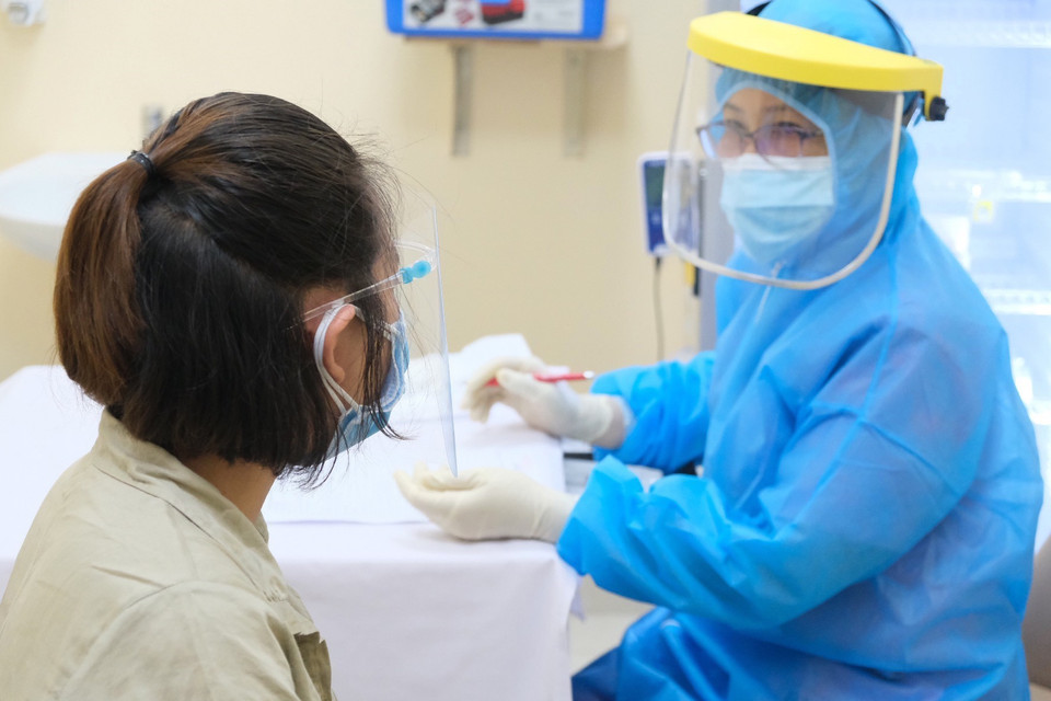 Bác sỹ Bệnh viện Hùng Vương Thành phố Hồ Chí Minh tư vấn trước khi tiêm vaccine phòng COVID-19 cho thai phụ. (Ảnh: TTXVN phát)