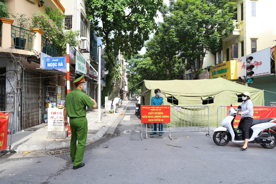 Lực lượng công an hướng dẫn người dân không vào khu vực bị phong tỏa. (Ảnh: Hoàng Hiếu/TTXVN)