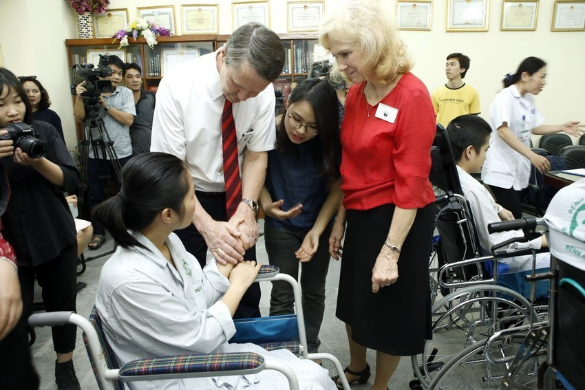 Ông Gerald Thomason - Trưởng đại diện Tổ chức Hội từ thiện Thánh hữu ngày sau (LDSC) tại Việt Nam và Phu nhân trao tặng xe lăn và thăm hỏi các bệnh nhân khiếm khuyết vận động, khuyết tật đang điều trị bệnh viện Bạch Mai. (Ảnh: Dương Ngọc/TTXVN)