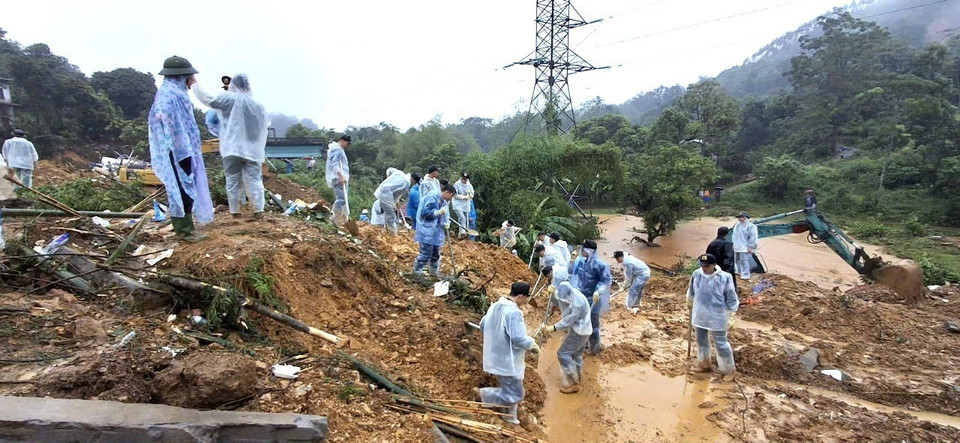 Cán bộ, chiến sỹ Công an tỉnh Hà Giang và các lực lượng chức năng nỗ lực tìm kiếm nạn nhân mất tích trong vụ sạt lở nghiêm trọng. (Ảnh: TTXVN phát)