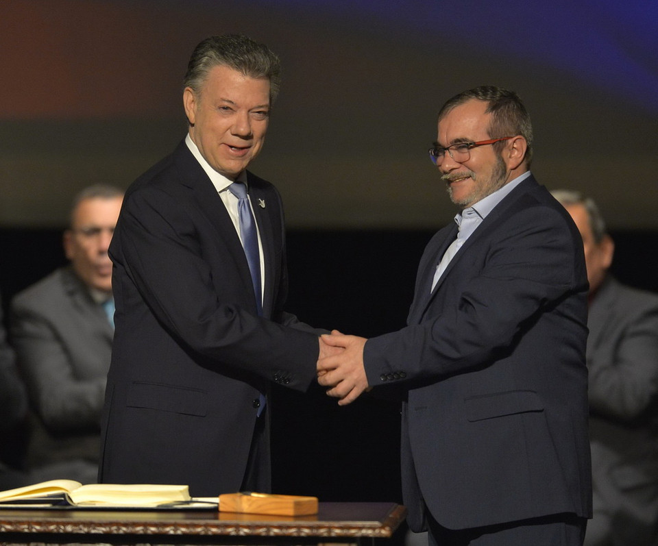 Colombia đạt thỏa thuận hòa bình lịch sử: Ngày 24/11, Tổng thống Colombia Juan Manuel Santos (trái) và Thủ lĩnh tối cao Lực lượng vũ trang Cách mạng Colombia (FARC) Rodrigo Londono (phải) đã ký thỏa thuận hòa bình sửa đổi nhằm chấm dứt cuộc nội chiến kéo dài 52 năm ở nước này. (Nguồn: AFP/ TTXVN)