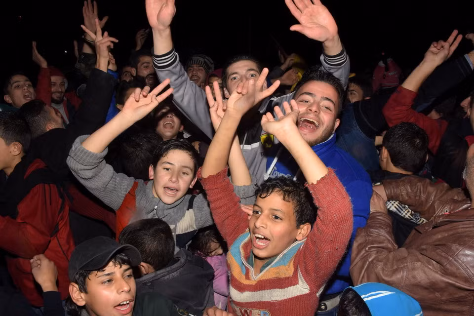Bước ngoặt lớn trong cuộc chiến tại Syria: Người dân Syria đổ ra đường mừng vui sau khi thành phố Aleppo được giải phóng hoàn toàn ngày 22/12. (Nguồn: AFP/TTXVN)