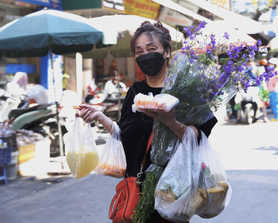  Người dân thủ đô mua hoa và những lễ vật để cúng tất niên và Giao thừa tại chợ Hàng Bè. (Ảnh: Hoàng Hiếu/TTXVN)