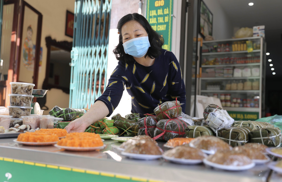 Xôi gấc, chè kho là đồ cúng được các tiểu thương bày bán nhiều ở chợ Hàng Bè. (Ảnh: Hoàng Hiếu/TTXVN)