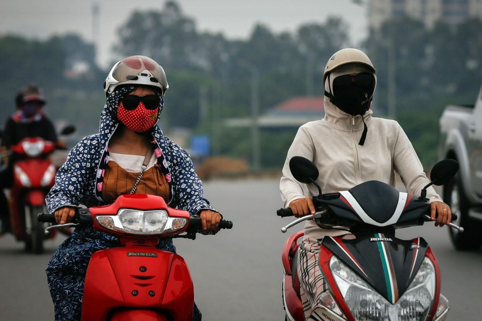 Trang phục kín mít của người dân thủ đô mỗi khi ra đường trong thời gian này, nhằm bảo vệ sức khỏe hạn chế sự ảnh hưởng của bụi. Người dân, đặc biệt là trẻ em, người lớn tuổi, phụ nữ mang thai, người mắc các bệnh hô hấp hạn chế khi ra ngoài. (Ảnh: Trọng Đạt/TTXVN)