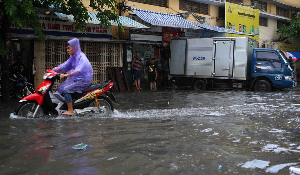 Nhiều cửa hàng kinh doanh trên phố Mạc Thị Bưởi phải đóng cửa do mưa ngập. (Ảnh: Thanh Tùng/TTXVN)