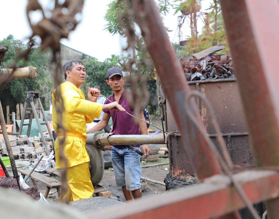 Nghệ nhân ưu tú Thiều Quang Tùng đang nấu chảy đồng. (Ảnh: Thanh Tùng/TTXVN)